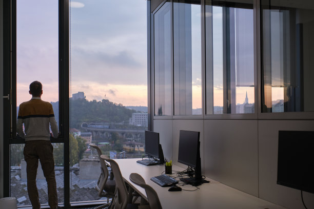 商业环境——商人站在办公室，看着窗外图片下载