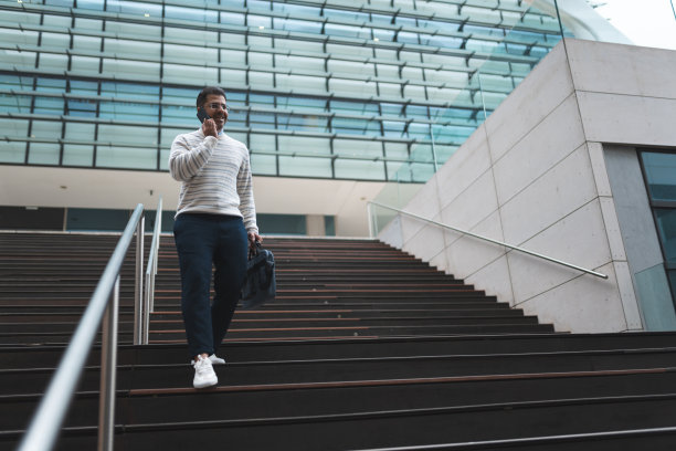 商务楼楼梯上有个男人在打电话图片下载