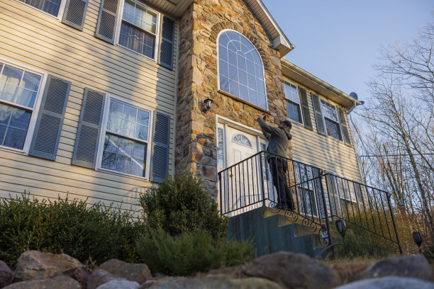 房地产经纪人正在美国宾夕法尼亚州的门廊上拍摄房子的照片。图片下载