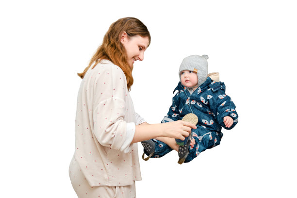 母亲把一条温暖的围巾套在白底上的蹒跚学步的婴儿身上。在寒冷的天气里，妈妈给孩子穿保暖的衣服。一岁零三个月的孩子图片下载