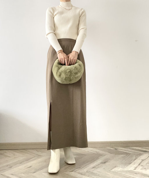 女人穿着棕色直铅笔裙，皮草包在白色靴子图片下载