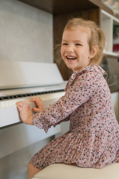 可爱的孩子在家里弹钢琴图片下载