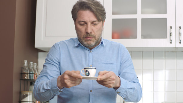 拎咖啡时尽量不把咖啡洒出来的男人。图片下载