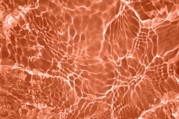 离焦模糊透明橙色透明平静的水面纹理与飞溅和气泡。潮流抽象的自然背景。水波在阳光下复制空间。红色水彩光泽图片下载