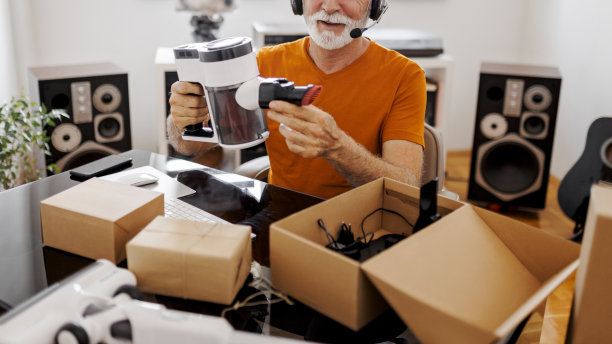 特写资深男性社交媒体技术影响者在家录制开箱视频图片下载