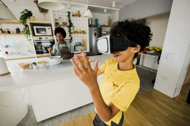 妈妈做饭时，男孩玩得很开心图片下载