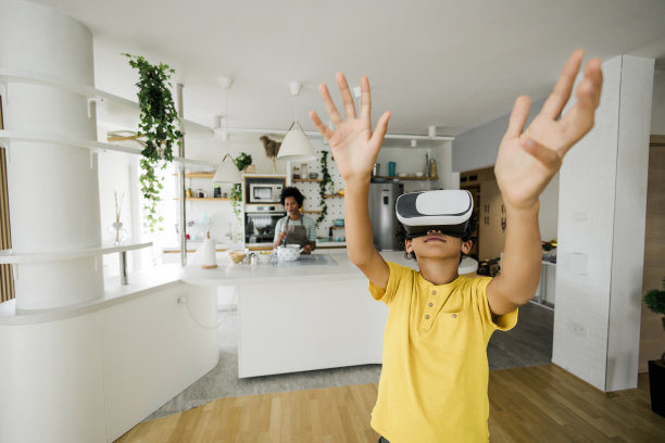 妈妈做饭时，男孩玩得很开心图片下载