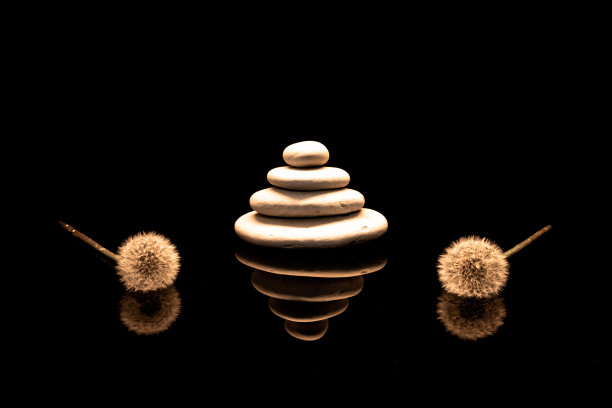 蒲公英的花朵在黑色的玻璃上摆出倒影。图片下载