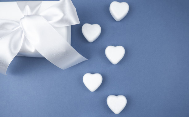 礼物白色盒子，蓝色背景上有白色的心。节日的概念。情人节。礼物。图片下载