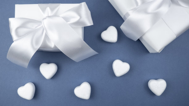 礼物白色盒子，蓝色背景上有白色的心。节日的概念。情人节。礼物。图片下载