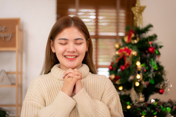 年轻的亚洲女子穿着毛衣，微笑着向上帝祈祷信仰，善良和宽恕图片下载