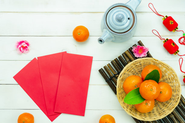 汉语的意思是富有或富有和幸福。俯视图航拍图像装饰春节春节假期背景概念。在现代的白色桌子上平铺着红橙花。图片下载