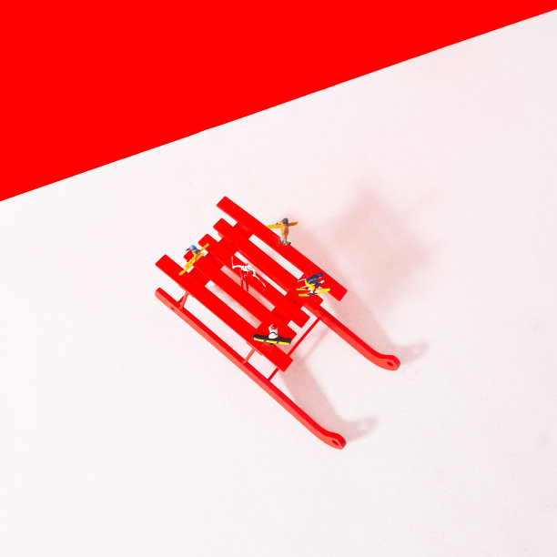 红色雪橇与迷你滑雪者在白色背景与红色天空上面。极简超现实概念的冬季假期在山区广告。为冬季滑雪场设计横幅或卡片图片下载