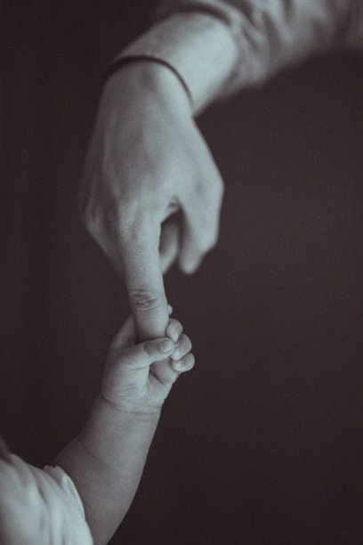 垂直拍摄的新生儿握着父亲的食指孤立在黑色背景上图片下载