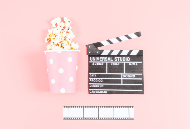 电影院的隔板，电影院的胶带和纸杯上撒着粉红色的爆米花图片下载