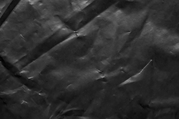 透明塑料袋包裹覆盖纹理的黑色背景图片下载