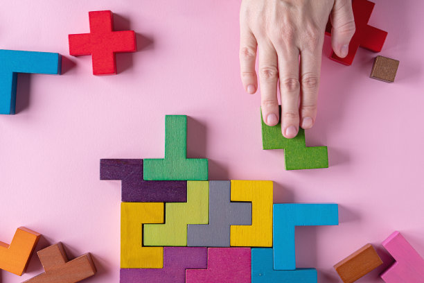 粉红色背景上不同颜色形状的木块图片下载