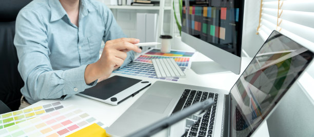 男性平面设计师正在多屏选择色块样品，在平板数码上绘图，在现代办公室中运用技术进行平面设计图片下载