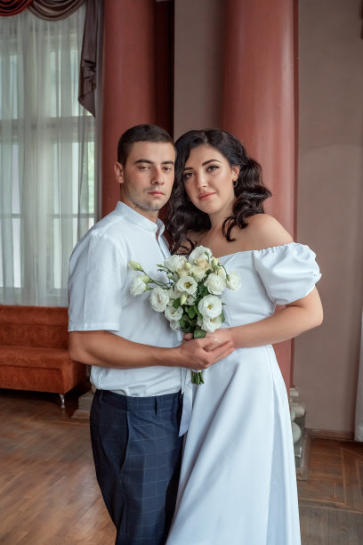 幸福的新娘和新郎：身穿白色复古礼服的男女在经典内饰中的婚礼肖像图片下载