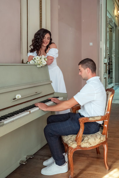 新郎在弹钢琴。大钢琴婚礼新郎新娘音乐。图片下载