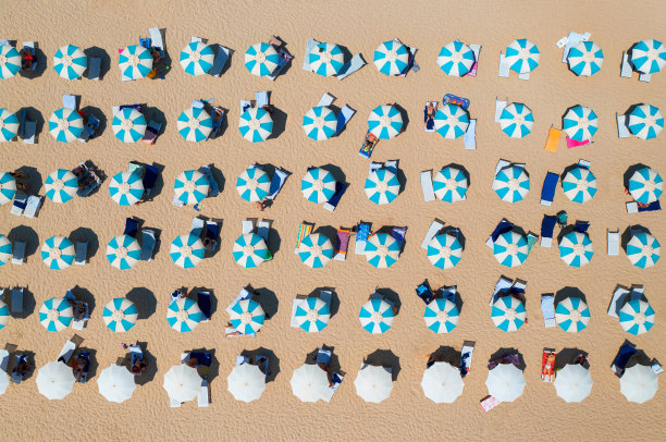 意大利撒丁岛，夏日夕阳下的人们，沙滩上五颜六色的雨伞鸟瞰图。热带景观。旅行和度假。从无人机上俯视。热带的模式。概念图片下载