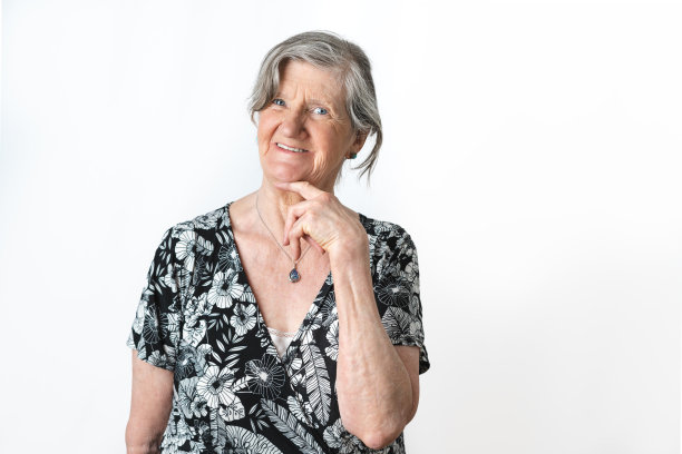 可爱的肖像老妇人摆姿势，看着相机在孤立的白色背景图片下载