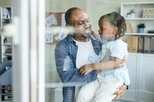 快乐的父亲在办公室拥抱可爱的孩子图片下载