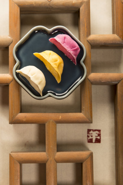 三种颜色的饺子和古老的中国窗框为喜庆的中国新年图片下载