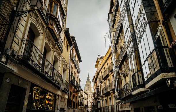历史名城的狭窄街道，有窗户，尽头是托莱多大教堂图片下载