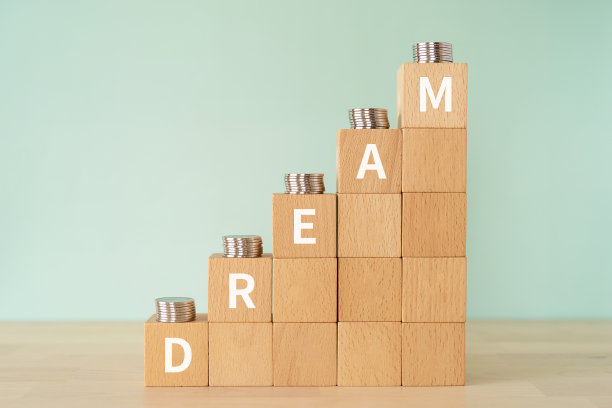 带有“DREAM”概念文本的木块和硬币。图片下载