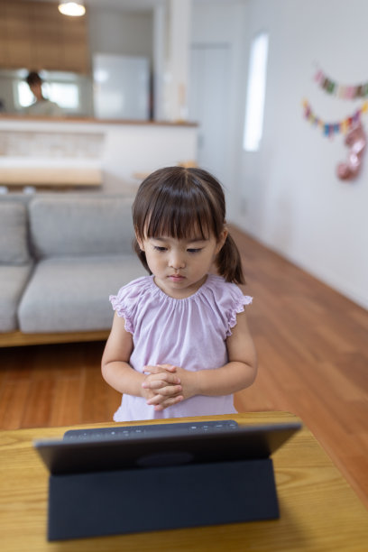 小女孩在家里通过平板电脑上的视频学习舞蹈图片下载