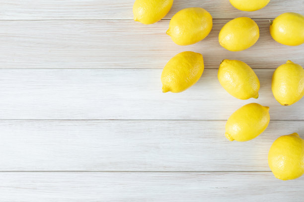 整个成熟的柠檬在白色的木头背景上。本空间图片下载