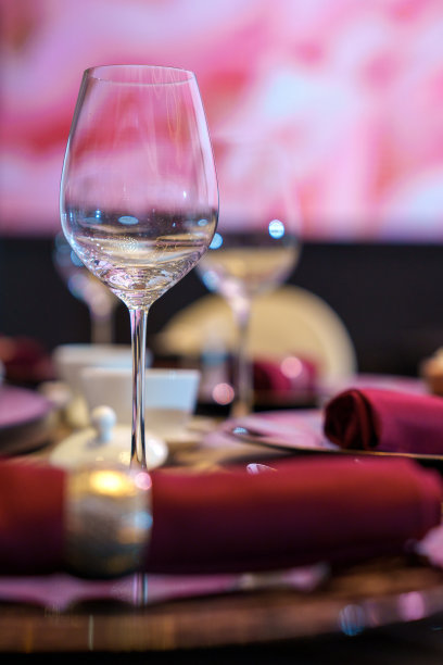 一套玻璃杯，盘子和餐具站在桌子上，豪华的服务在餐厅装饰的桌子上。图片下载