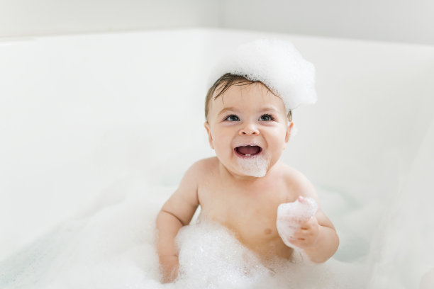 小男孩在有泡沫和肥皂泡的浴缸里洗澡图片下载