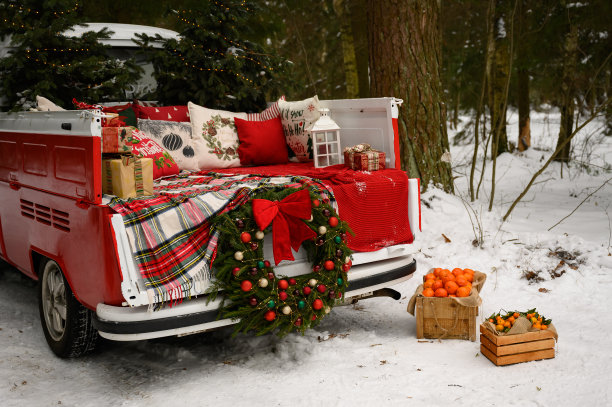 一辆装饰着圣诞装饰品和圣诞树的红色汽车停在冬天的森林里。新年的节日概念。家庭照片的装饰图片下载