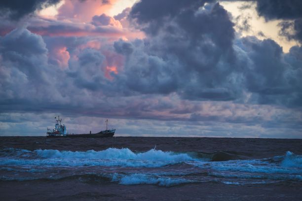 在阴天的海洋上，一艘满载着人的大船的特写镜头图片下载