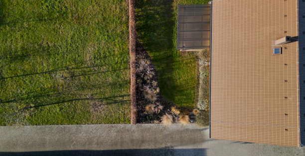 露台的房子在一个美丽的花园，配备了一个花园家具制成金属丝椅子和椭圆形的桌子。灰色混凝土砖露台。开花和观赏草图片下载