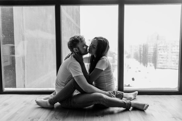 微笑可爱的多民族情侣在阳台上温柔拥抱图片下载