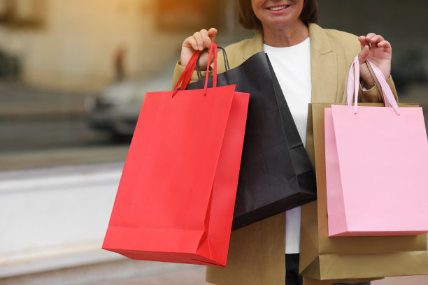 “黑色星期五”。带着购物袋的微笑成年女子。中年女性购物后对商场背景。购买，折扣，销售概念。网上购物概念，季节性销售。模型图片下载