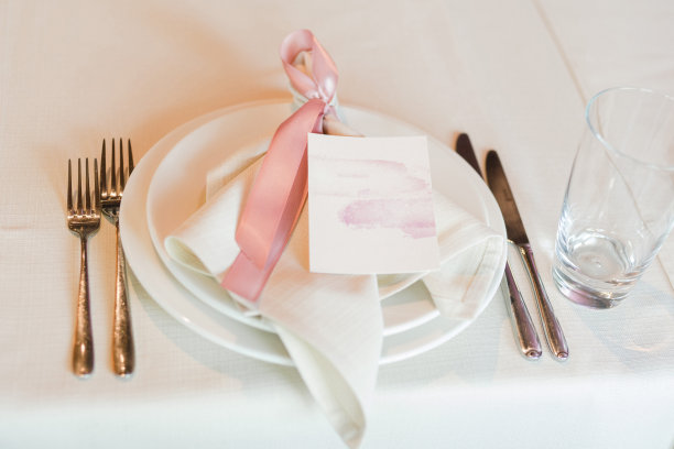 婚宴上的餐桌摆设。有美丽的花朵和绿色植物，蜡烛，在装饰好的桌子上摆放和盘子。图片下载