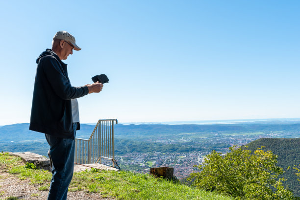 男子使用遥控驾驶无人机拍摄风景视频和照片图片下载
