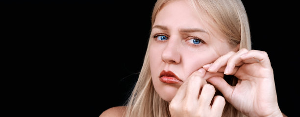 第二下巴，肥胖。照片中，一名30岁的女子拉起下巴，沮丧地看着镜头。老化和外观问题。整容手术图片下载