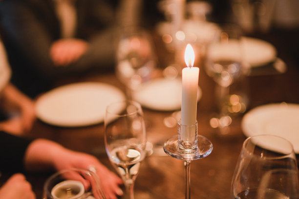 婚宴上的餐桌摆设。有美丽的花朵和绿色植物，蜡烛，在装饰好的桌子上摆放和盘子。图片下载