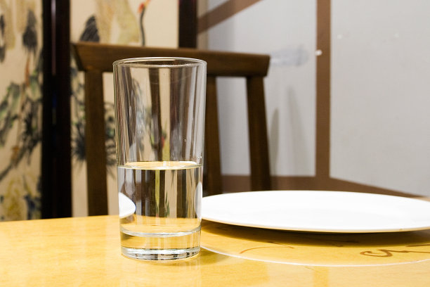 在米色背景的桌子上放一杯水图片下载