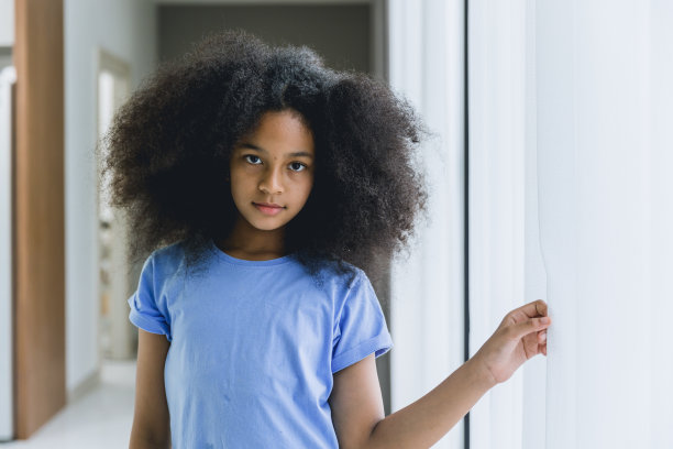 非洲儿童，十岁前的女孩爆炸发型混合种族站立自信的微笑图片下载