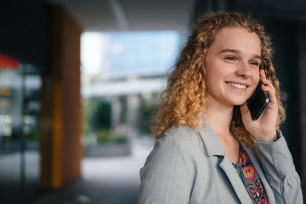 积极开朗的女学生，带着教科书和笔记本电脑去上大学课，用智能手机聊天。快乐的生活方式。在线教育，数字化学习。远程学习。图片下载