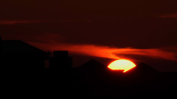 夕阳落在美国市中心的轮廓线后面。史诗般的日落和城市地标建筑。红色和橙色的太阳在黄色的天空上落下黄昏。图片下载
