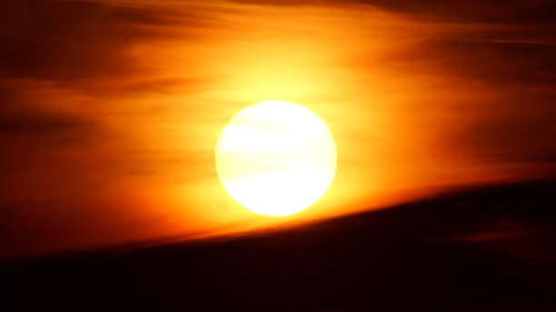 Vview橙黄色和红色日落天空与云。一天结束了。夏天雨后的黄昏。史诗般的太阳落山与大圈太阳下山到黄昏。晚上的天空。图片下载