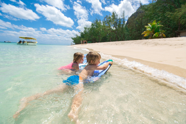 双胞胎兄妹在海里冲浪玩得很开心图片下载