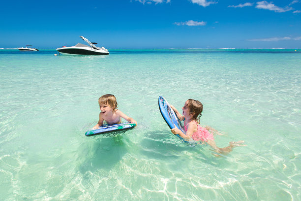 双胞胎兄妹在海里冲浪玩得很开心图片下载